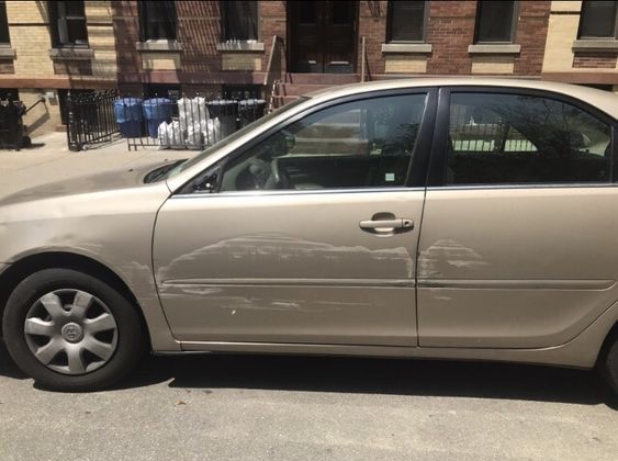 A tan sedan with scratches on the side